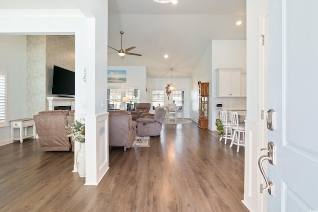 living room featuring dark hardwood / wood-style floors, ceiling fan, and high vaulted ceiling