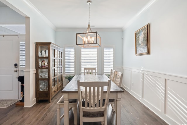 dining area featuring dark hardwood / wood-style floors, crown molding, and a notable chandelier