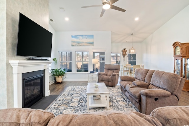 living room with ceiling fan, high vaulted ceiling, and dark wood-type flooring