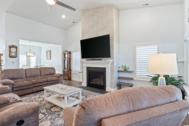 living room featuring a large fireplace, dark hardwood / wood-style floors, and a wealth of natural light