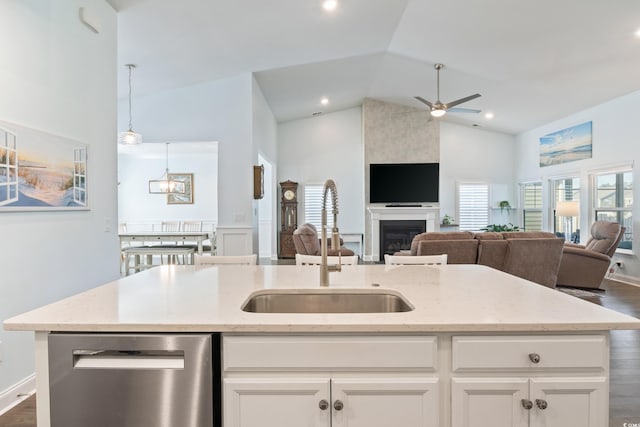 kitchen with white cabinets, dishwasher, light stone countertops, and sink