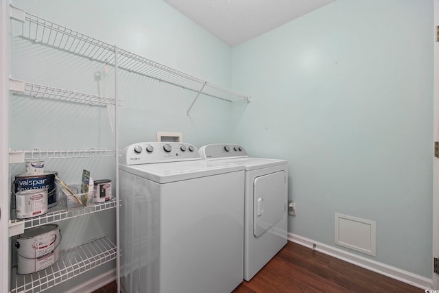 washroom featuring a textured ceiling, washer and dryer, and dark hardwood / wood-style floors