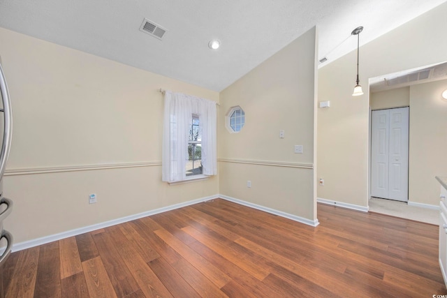 empty room featuring hardwood / wood-style floors and lofted ceiling