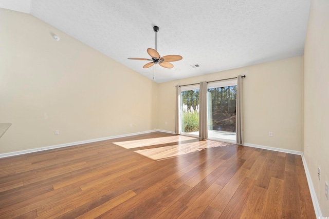 unfurnished room with a textured ceiling, hardwood / wood-style flooring, ceiling fan, and lofted ceiling