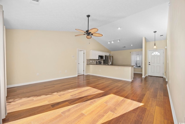 unfurnished living room featuring rail lighting, high vaulted ceiling, light hardwood / wood-style flooring, and ceiling fan