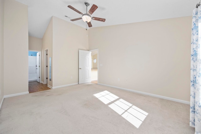 unfurnished bedroom featuring high vaulted ceiling, ceiling fan, light carpet, and connected bathroom