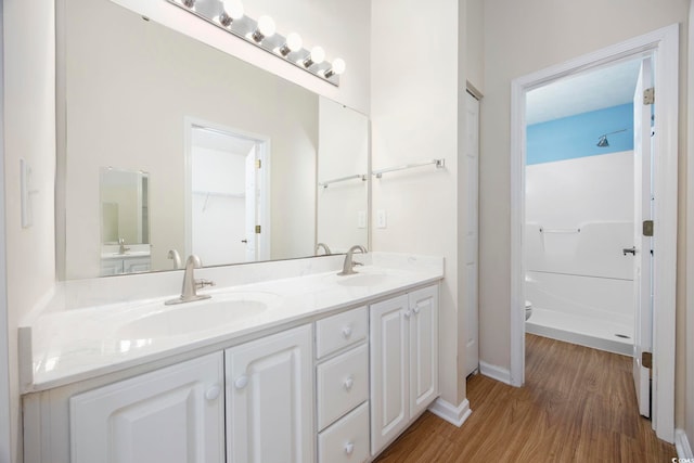 bathroom featuring a shower, wood-type flooring, and vanity