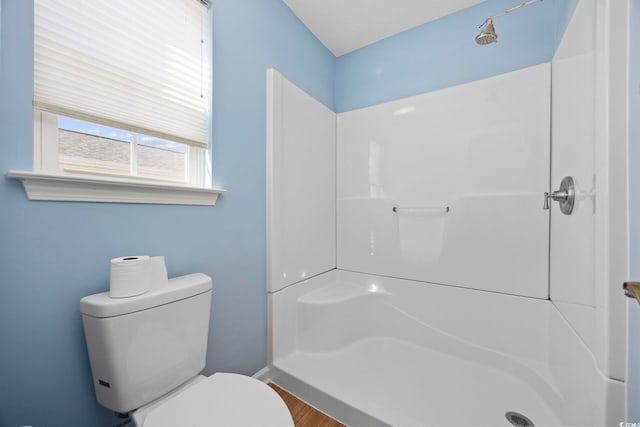 bathroom featuring toilet, hardwood / wood-style floors, and walk in shower