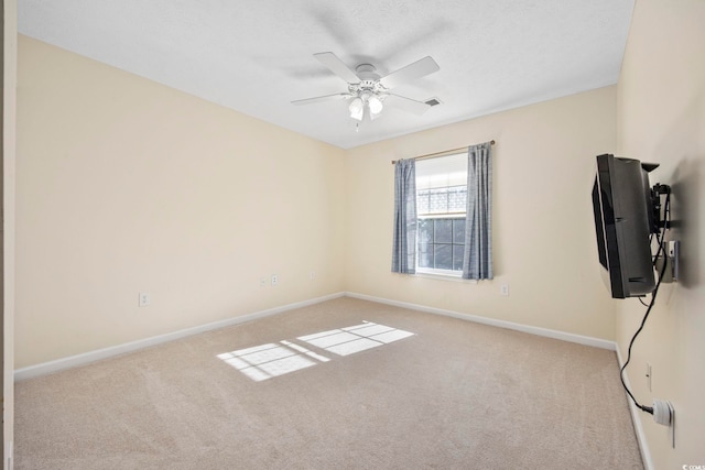 carpeted spare room with ceiling fan