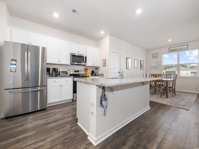 kitchen with white cabinetry, stainless steel appliances, and an island with sink