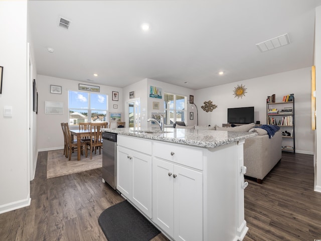 kitchen featuring stainless steel dishwasher, white cabinetry, a kitchen island with sink, and a wealth of natural light