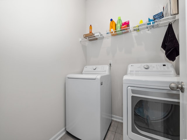 clothes washing area with washer and clothes dryer and light tile patterned floors