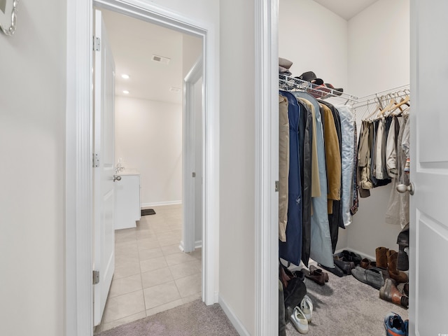 walk in closet with light tile patterned floors