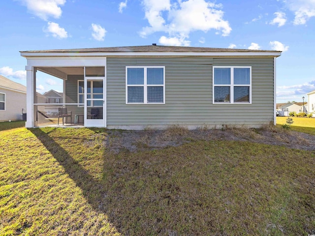 back of house with a sunroom and a yard