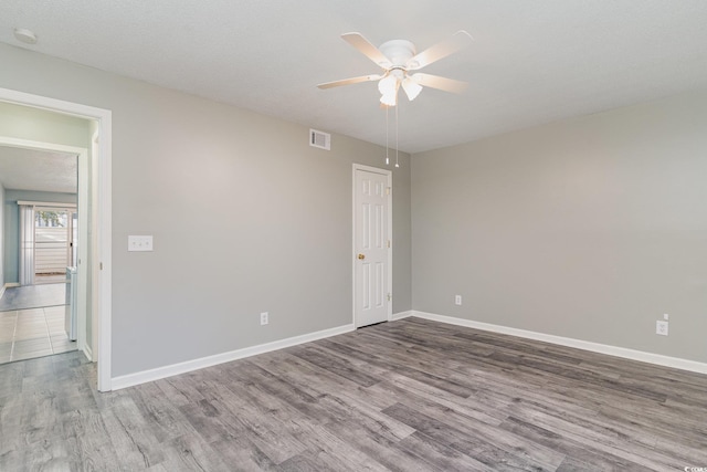 unfurnished room with ceiling fan, hardwood / wood-style floors, and a textured ceiling