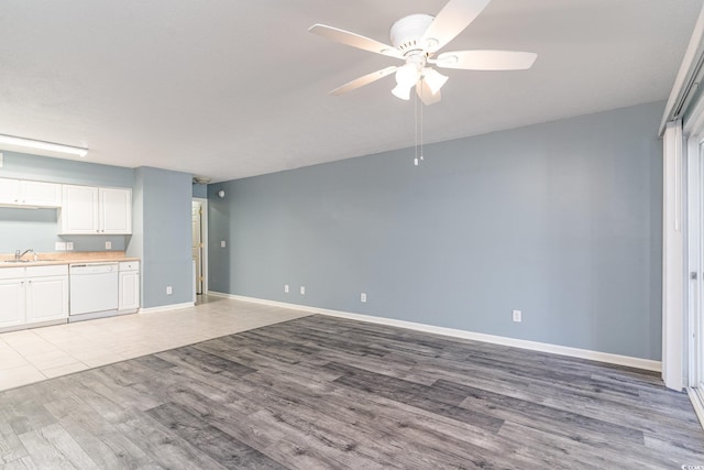 unfurnished living room with ceiling fan, sink, and light hardwood / wood-style floors