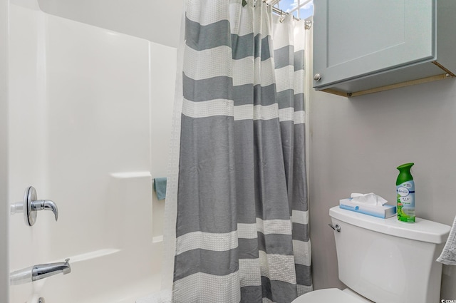 bathroom featuring a shower with shower curtain and toilet