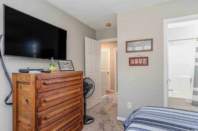 bedroom featuring connected bathroom, light carpet, and a textured ceiling