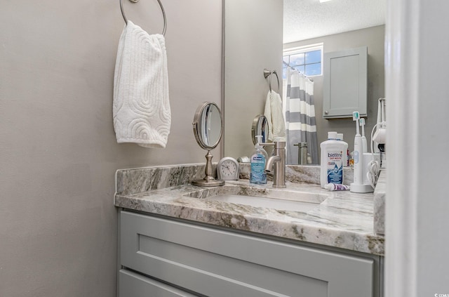 bathroom featuring a textured ceiling and vanity