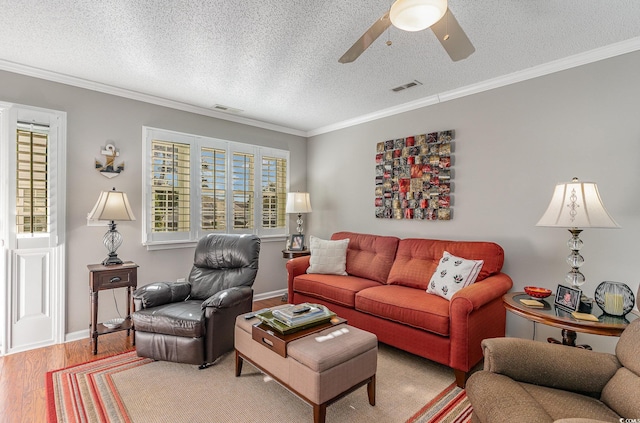 living room featuring hardwood / wood-style flooring, ceiling fan, ornamental molding, and a textured ceiling