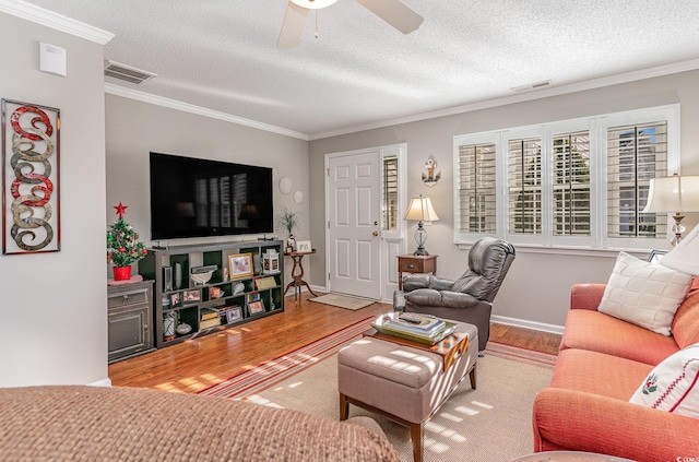 living room with crown molding, ceiling fan, a textured ceiling, and hardwood / wood-style flooring