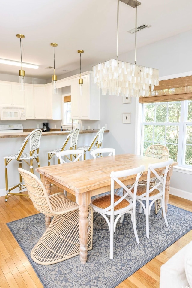 dining space featuring an inviting chandelier and light hardwood / wood-style flooring