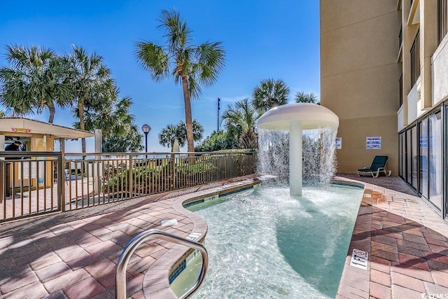 view of swimming pool featuring pool water feature and a patio