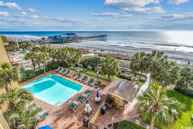 birds eye view of property featuring a water view and a beach view