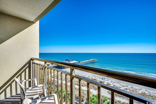 balcony featuring a view of the beach and a water view