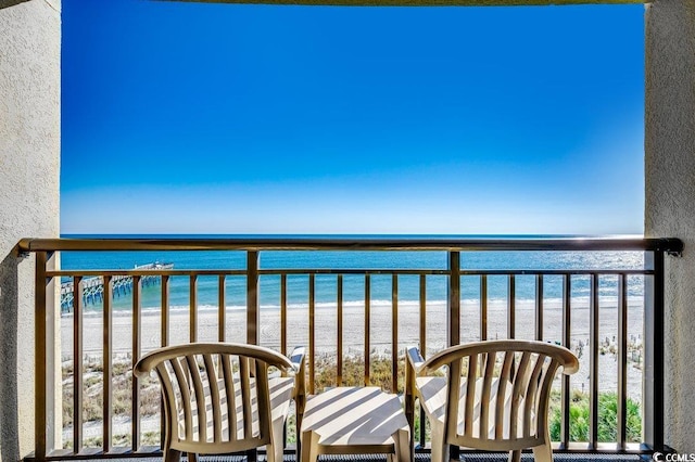 balcony featuring a water view and a view of the beach