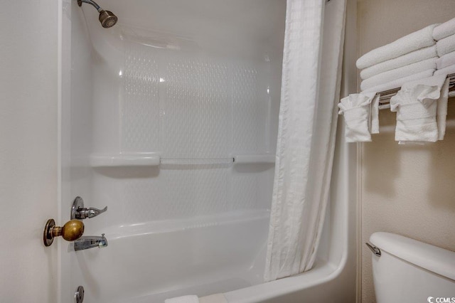 bathroom with shower / bath combination with curtain and toilet