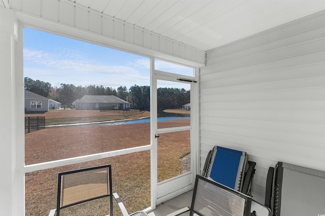 sunroom / solarium with a water view and a healthy amount of sunlight