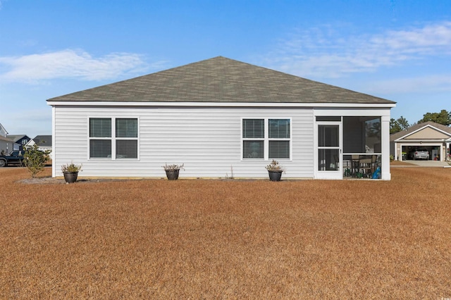 rear view of house featuring a yard and a sunroom