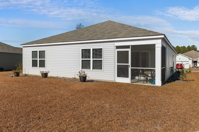 rear view of property with a lawn and a sunroom