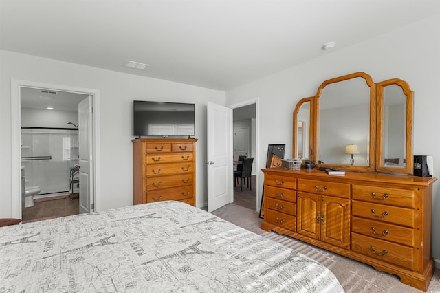 bedroom with light carpet and ensuite bath