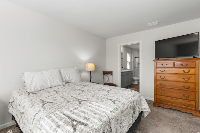 carpeted bedroom featuring ensuite bath