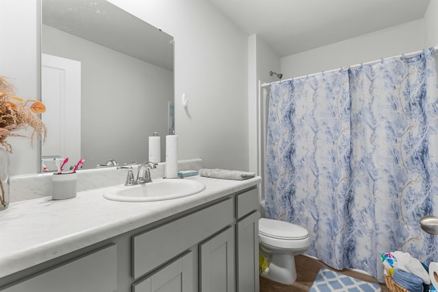 bathroom featuring hardwood / wood-style floors, vanity, a shower with shower curtain, and toilet