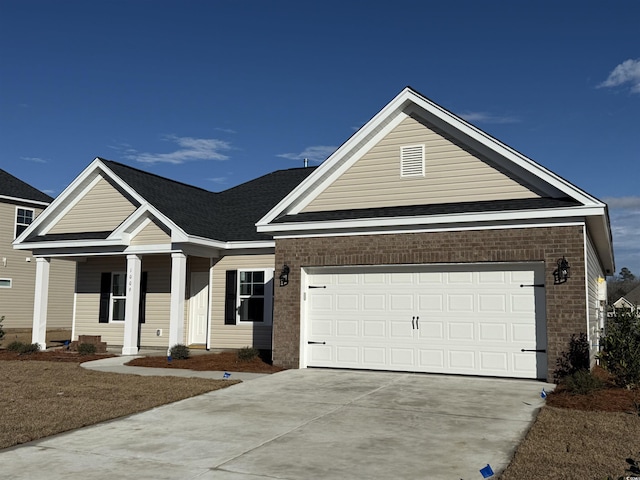 view of front of house featuring concrete driveway, an attached garage, brick siding, and roof with shingles