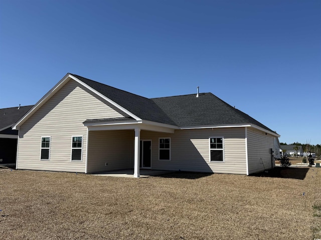 back of house featuring a patio area and a shingled roof