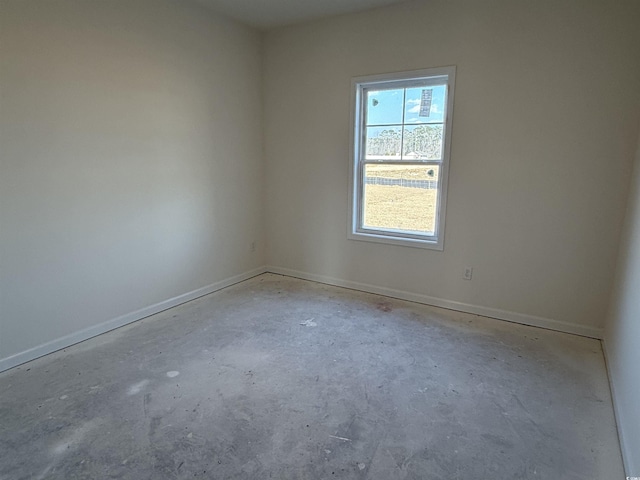 unfurnished room with concrete flooring and baseboards