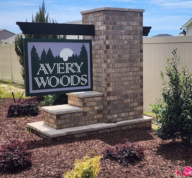 community / neighborhood sign featuring fence