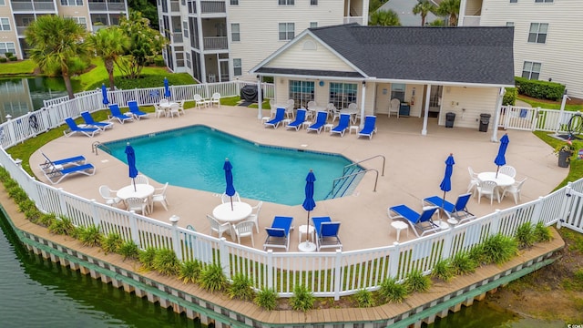 view of pool with a patio and a water view