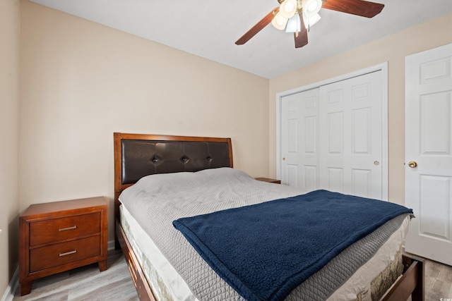 bedroom with ceiling fan, a closet, and light hardwood / wood-style floors