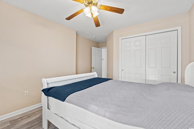 bedroom with ceiling fan, a closet, and hardwood / wood-style flooring