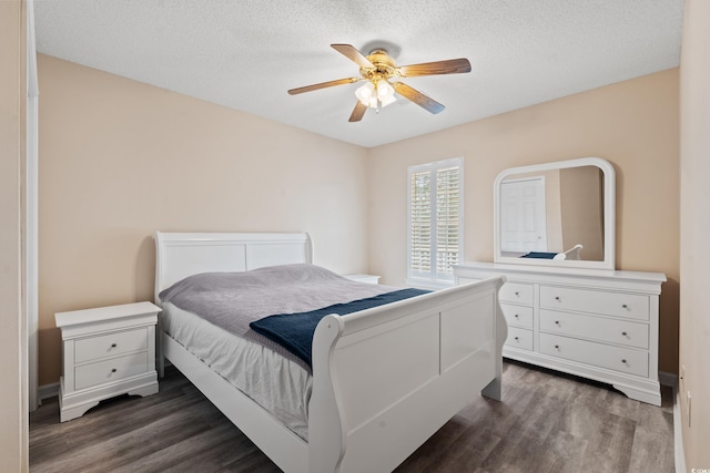 bedroom with ceiling fan, dark hardwood / wood-style flooring, and a textured ceiling