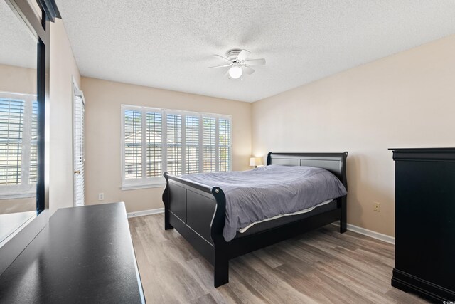 bedroom featuring wood-type flooring, a textured ceiling, and ceiling fan