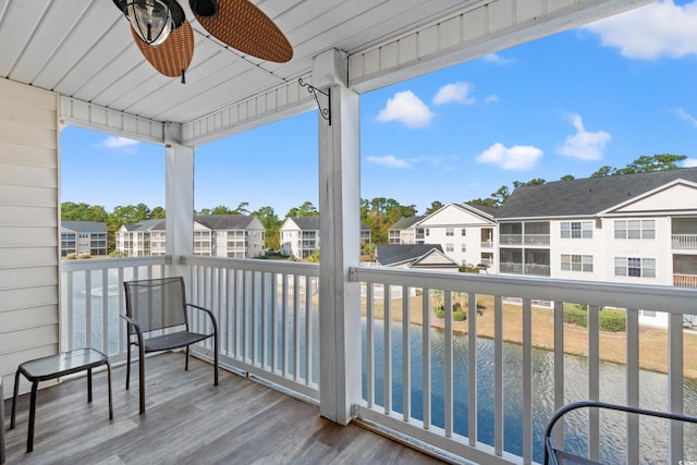 balcony with ceiling fan and a water view