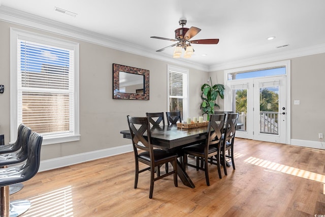 dining area with light wood-type flooring, a wealth of natural light, crown molding, and ceiling fan