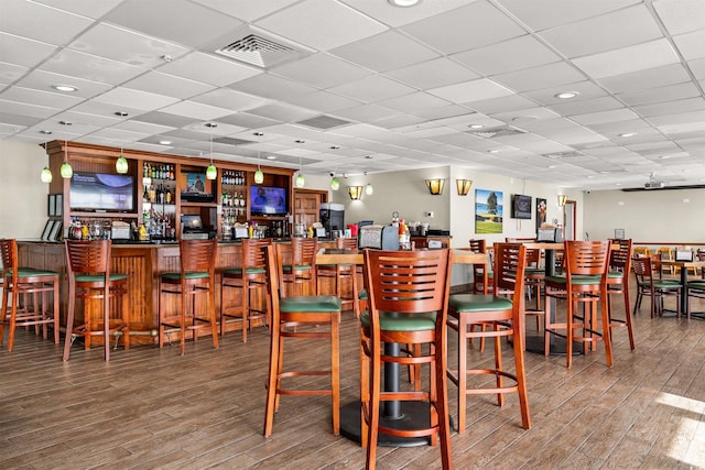 bar featuring hardwood / wood-style floors and a drop ceiling