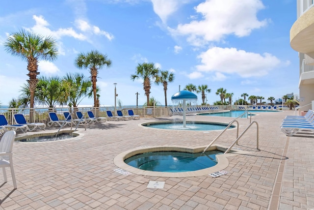 view of swimming pool featuring a patio and a community hot tub